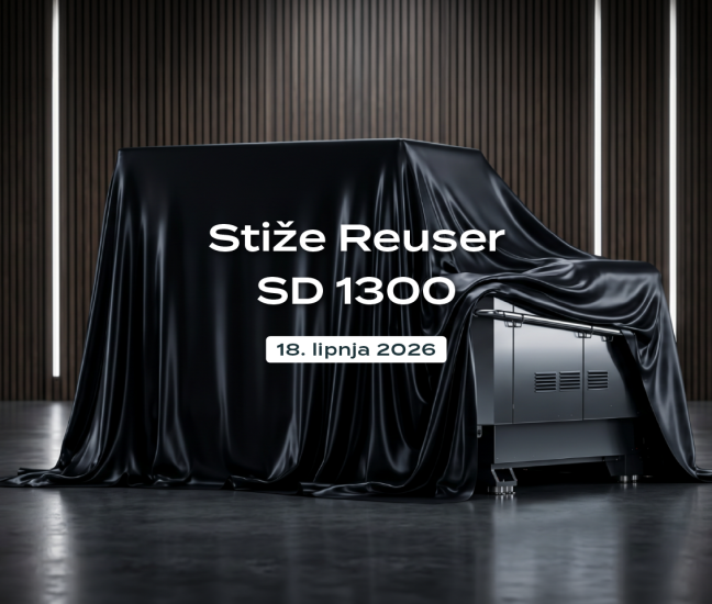 Industrijska drobilica Robust Reuser SD 1300, tajanstveno prekrivena crnim prekrivačem u modernom salonu. Slika uključuje logotip Robust Reuser i tekst: Stiže Reuser SD 1300, 18. lipnja 2026.