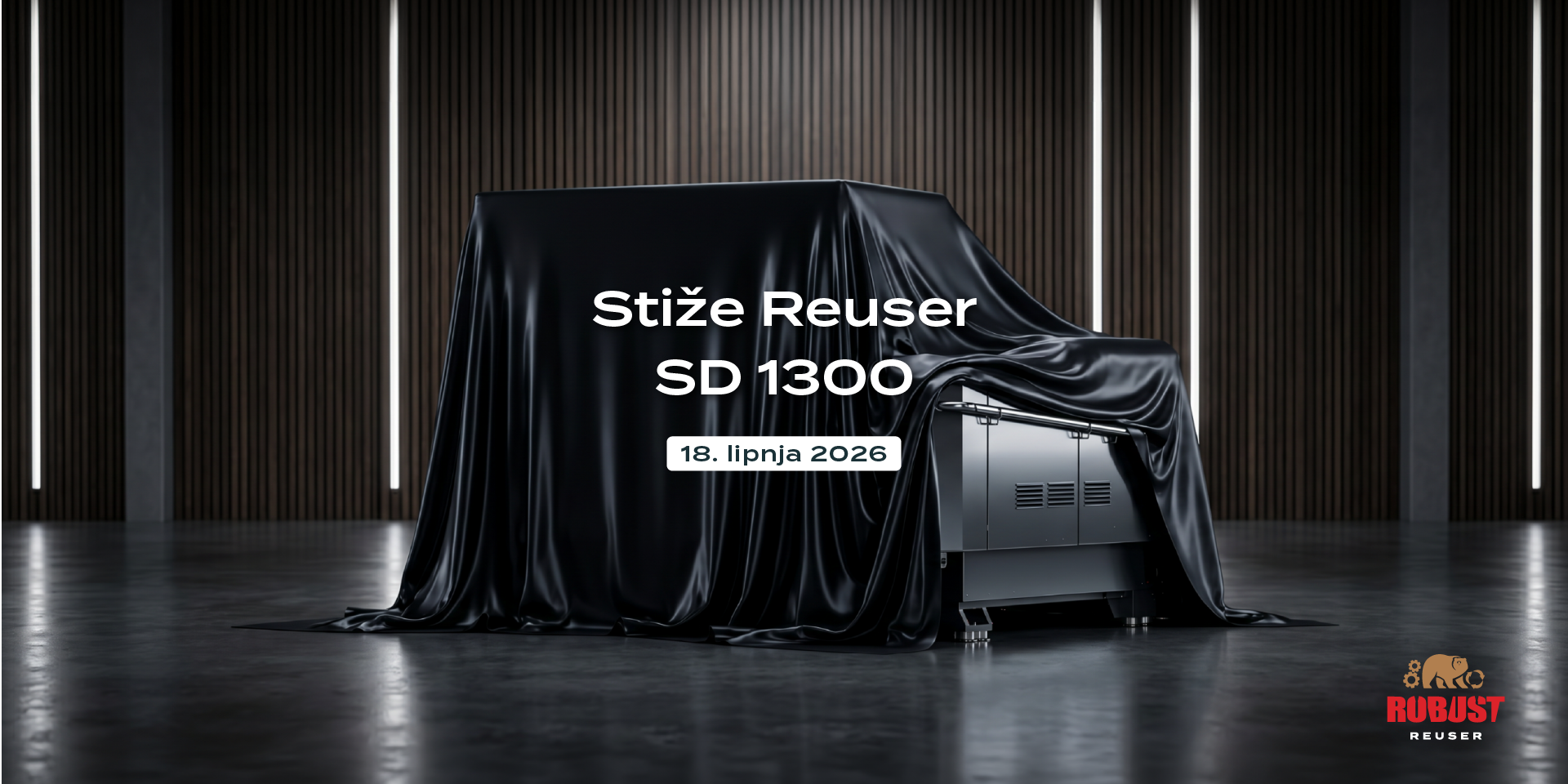 Industrijski drobilnik Robust Reuser SD 1300, tajanstveno prekriven crnim prekrivačem u modernom salonu. Slika uključuje logotip Robust Reuser i tekst: Stiže Reuser SD 1300, 18. lipnja 2026.